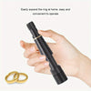 A hand holds a black ring expander tool and a pair of gold rings, demonstrating how to easily expand a ring at home.