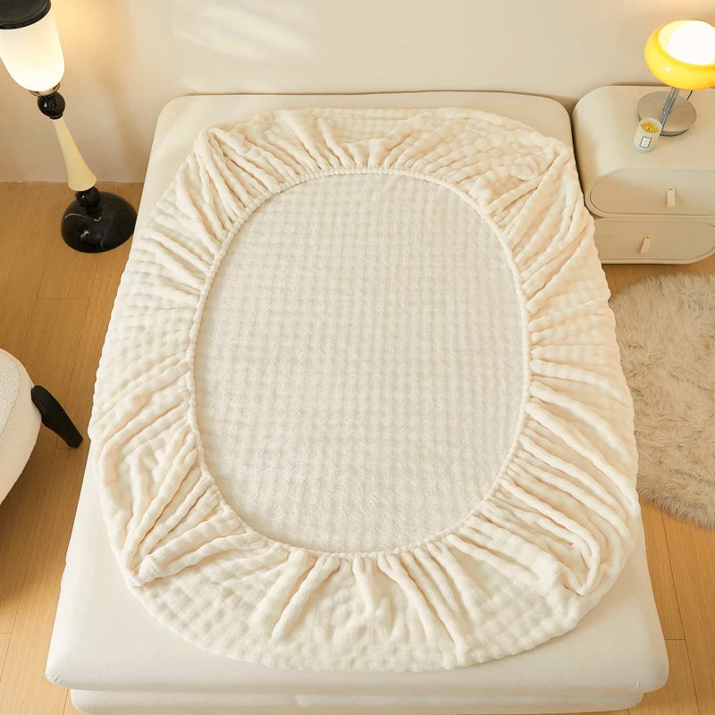 A beige cozy faux fur fitted sheet displayed on a white mattress.