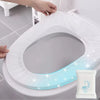 A hand is placing a disposable toilet seat cover onto a white toilet, highlighting the individually wrapped product.