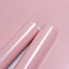 Rolls of glitter pink peel-and-stick vinyl contact paper shown against a pink background.