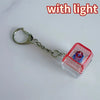 A silver chain keychain featuring a red and clear plastic component with a blue LED light inside.