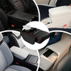 A car armrest cushion with cup holders and storage is shown in various angles inside a vehicle.