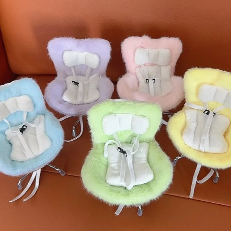 A collection of five pastel-colored miniature doll seats with white vent decorations.