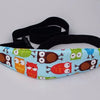 A black adjustable baby car seat sleeping headrest with a colorful fabric cover and a black belt strap.