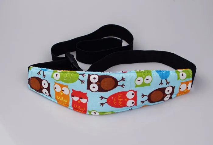 A black adjustable baby car seat sleeping headrest with a colorful fabric cover and a black belt strap.