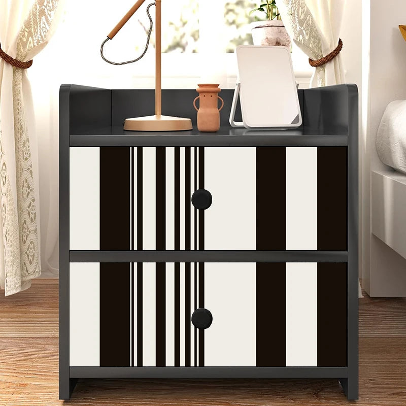 A black and white striped self-adhesive wallpaper roll displayed on a dark cabinet with a window view.