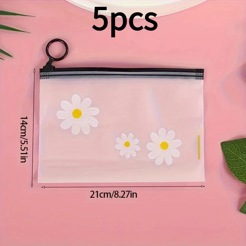 A set of five clear frosted zipper bags with white daisy patterns displayed on a pink background.