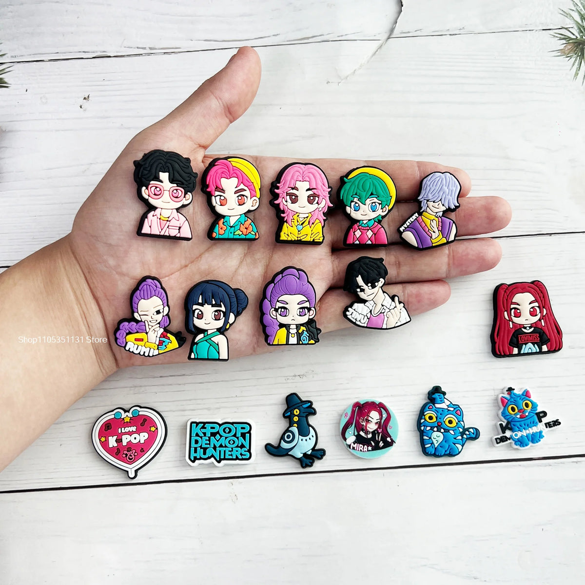 Une main montre une collection de charms de chaussures de personnages de dessins animés chibi d'anime et de jeux vidéo.