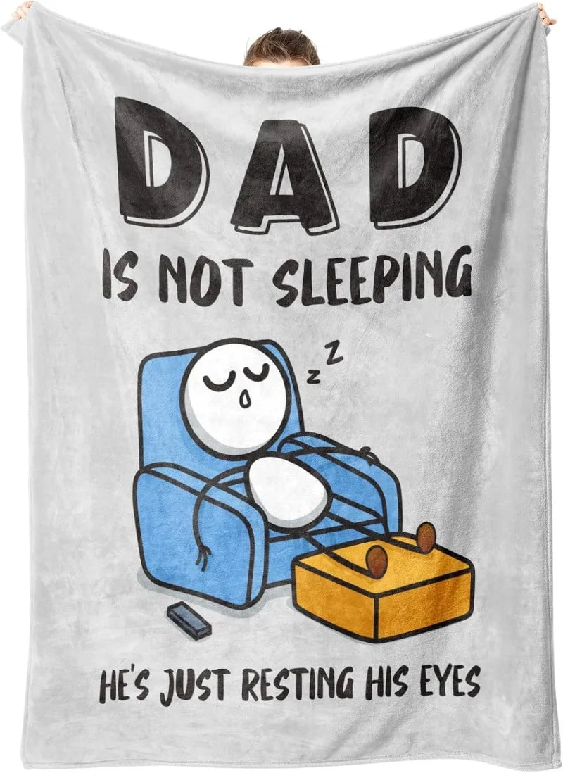 A gray fleece throw blanket featuring a graphic of a sleeping figure with the text Dad is not sleeping He's just resting his 