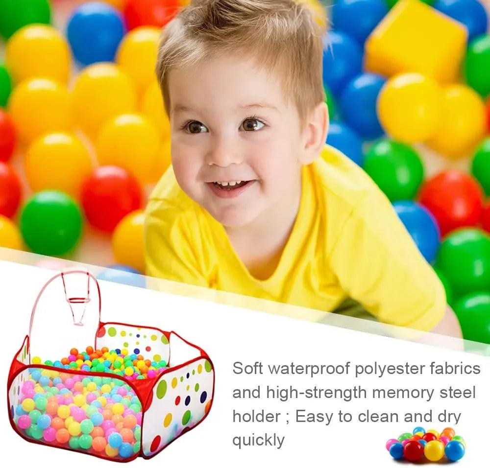 A young boy smiling while playing in a colorful ball pit with a storage basket.