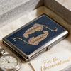 A vintage metal card and cash case with an art deco design featuring a gold leopard print on a dark blue background.