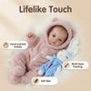 A lifelike reborn baby doll with a pink fluffy outfit and soft skin texture.