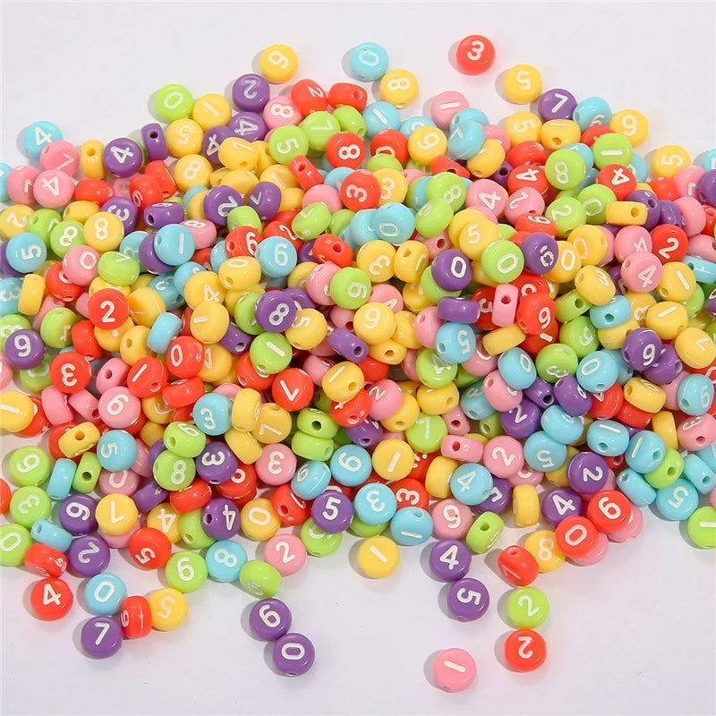 A large pile of colorful acrylic alphabet letter beads in various shades of pink, yellow, green, blue, and red.