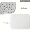 A view of a white bathroom accessory set featuring a patterned rug material on the back side and a smooth white front side.