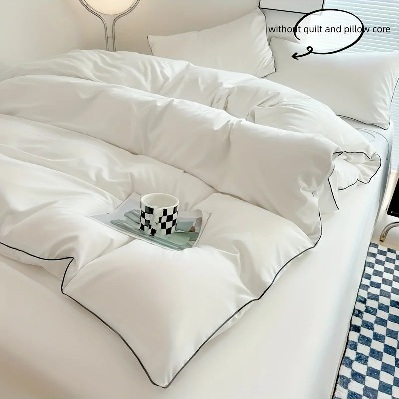 A white duvet cover set with matching pillowcases is displayed on a bed, featuring a checkered accent.