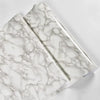 A close-up view of marble peel-and-stick wallpaper featuring white and gray veining.