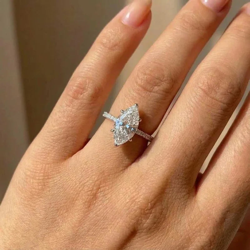 Gros plan d'une bague en argent sterling avec zircon marquise portée à un doigt.