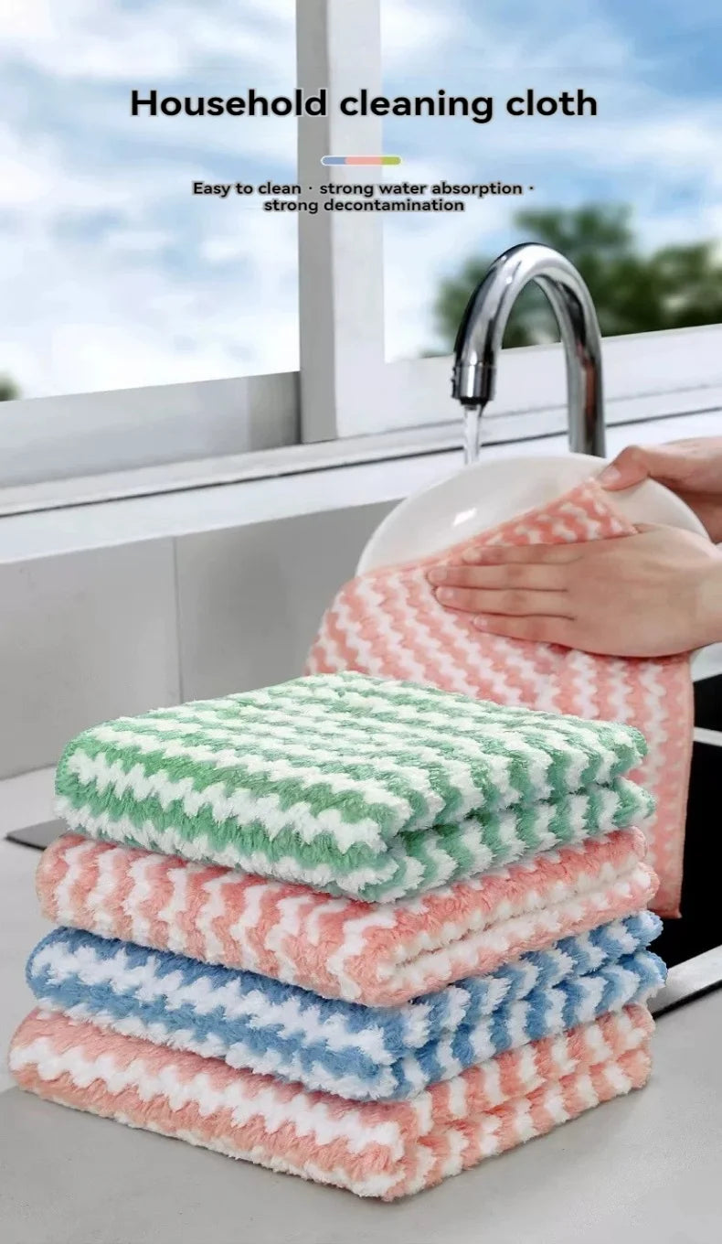 A stack of pink and green microfiber household cleaning cloths next to a kitchen faucet.