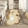 A beige and brown irregular area rug with a white line design placed on a light wood floor.