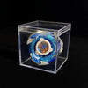 A metal spinning top featuring blue and silver accents displayed inside a clear plastic box.