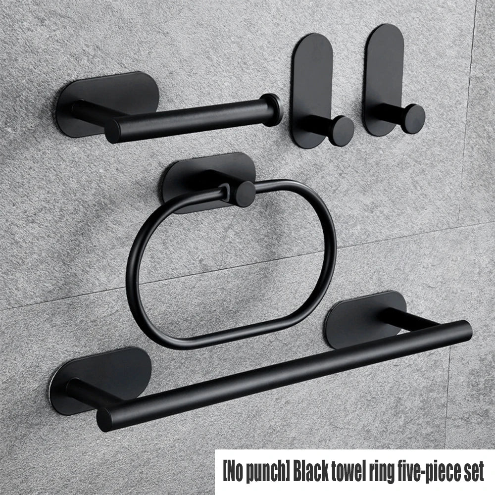 A five-piece black towel ring set with adhesive mounting hardware displayed against a gray wall.