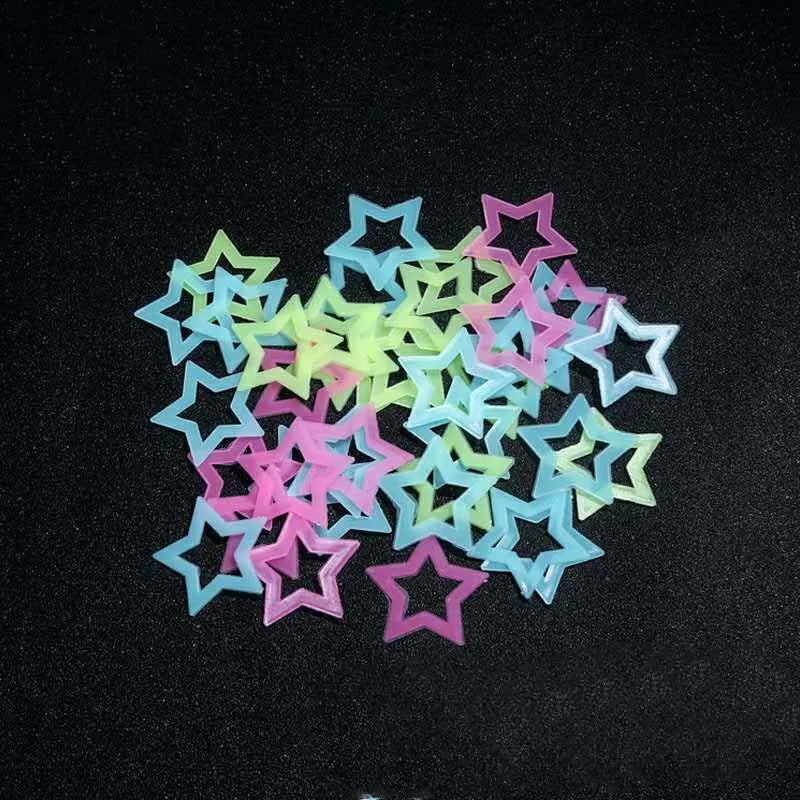 A collection of glow-in-the-dark 3D star wall stickers in various pastel colors scattered on a dark surface.