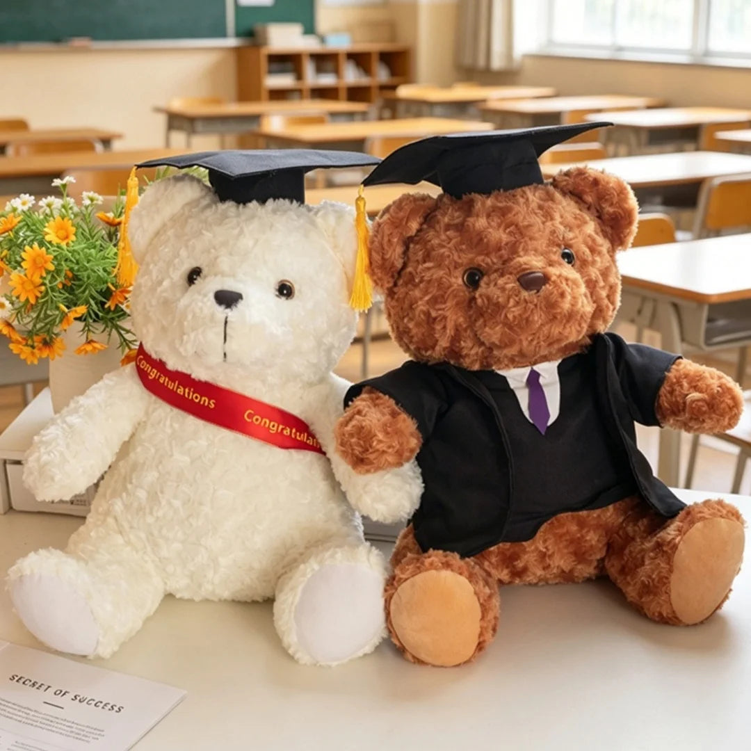 Un ours en peluche blanc avec une toque et une robe de graduation, assis à côté d'un ours brun en costume de remise de diplôm