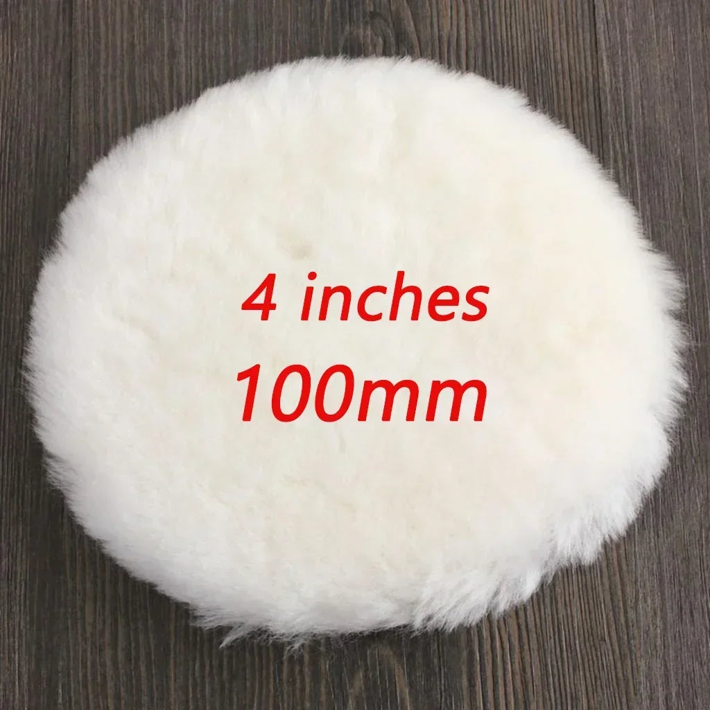 A white, fluffy wool polishing pad is shown on a dark wooden surface.