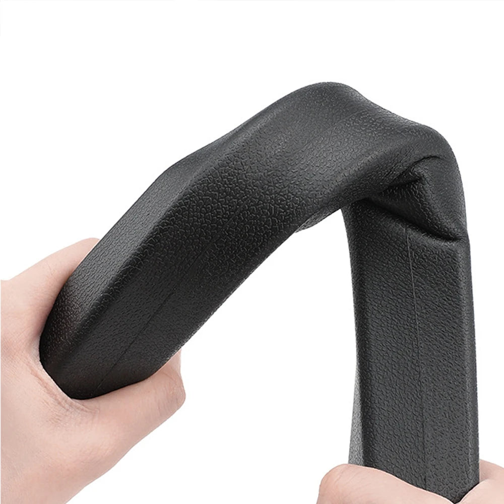 A hand holds a black universal car seat gap filler and storage organizer, showing its shape and texture.