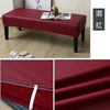 A deep red waterproof PU stretch bench cover displayed on a wooden floor, showing close-ups of the fabric texture and elastic