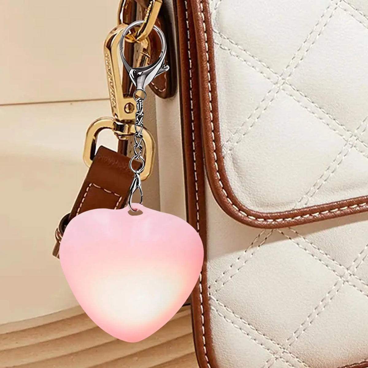 A heart-shaped rechargeable light attached to a leather purse strap.