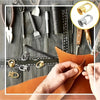A close-up of a leather item being stitched, surrounded by various metal hardware and tools for crafting.