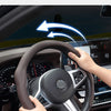 Eine Hand dreht eine schwarze Lenkradabdeckung im Autointerieur und demonstriert ihre rutschfeste Funktion.