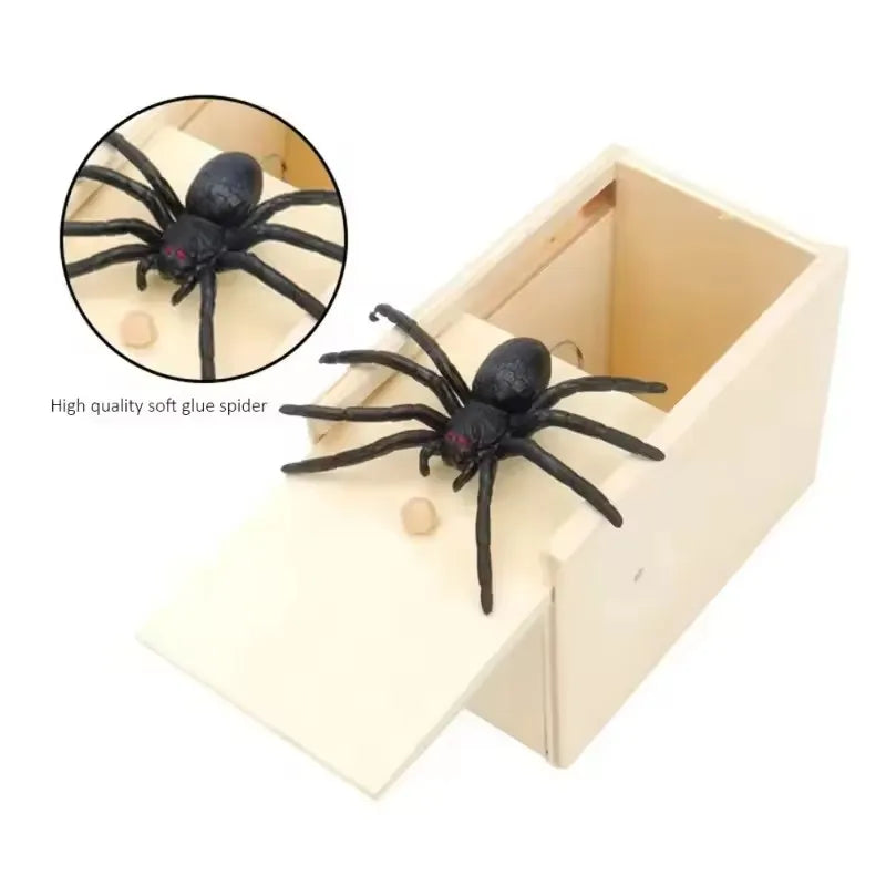 A black soft glue spider is shown inside a light wooden box, demonstrating a surprise pop-out trick toy.