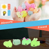 A hand holds several glow-in-the-dark, pink and yellow kawaii animal squishies against a light background.