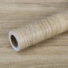 Roll of self-adhesive wood grain waterproof wallpaper on a wooden surface
