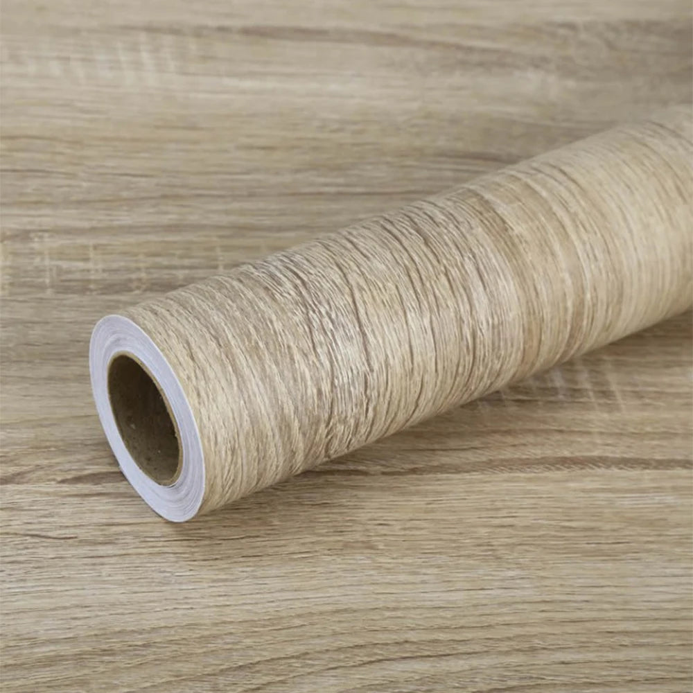 Roll of self-adhesive wood grain waterproof wallpaper on a wooden surface
