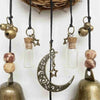 A collection of brass and glass witch bells hanging from a wicker basket