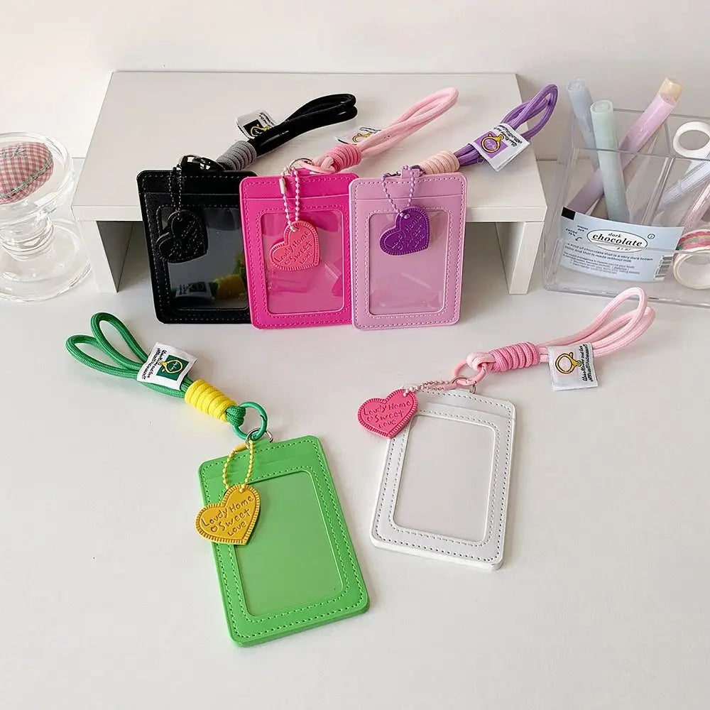 Eine Sammlung von rosa, grün und schwarz PU-Leder-Kartenhüllen mit verschiedenfarbigen Lanyards auf einem weißen Tisch.