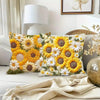 A close-up of a yellow and white floral cushion cover featuring sunflowers and daisies on a light gray sofa.