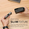 A hand holds a slim black aluminum wallet with a money clip on a wooden surface.