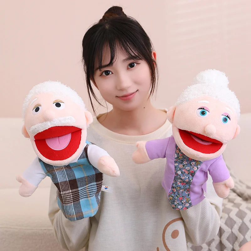 A young woman is holding two soft plush hand puppets, one with a white beard and another with white hair.