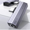A silver USB-C to 3.5mm audio adapter with charging support lying on a white surface.