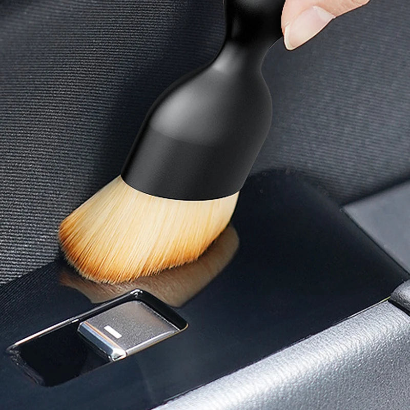 A black soft-bristle cleaning brush is shown inside its protective case, ready for use.