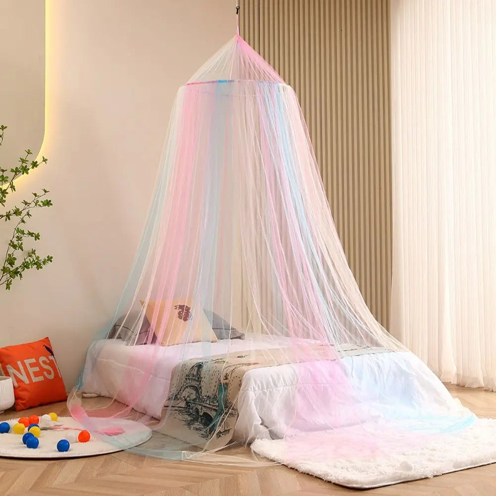 A rainbow colored hanging dome canopy mosquito net draped over a bed in a bright room.