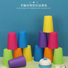 A stack of colorful plastic cups in various shades of pink, purple, blue, and yellow, demonstrating hand-eye coordination.