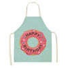 A light mint green apron with a pink birthday cake design featuring the word HAPPY BIRTHDAY