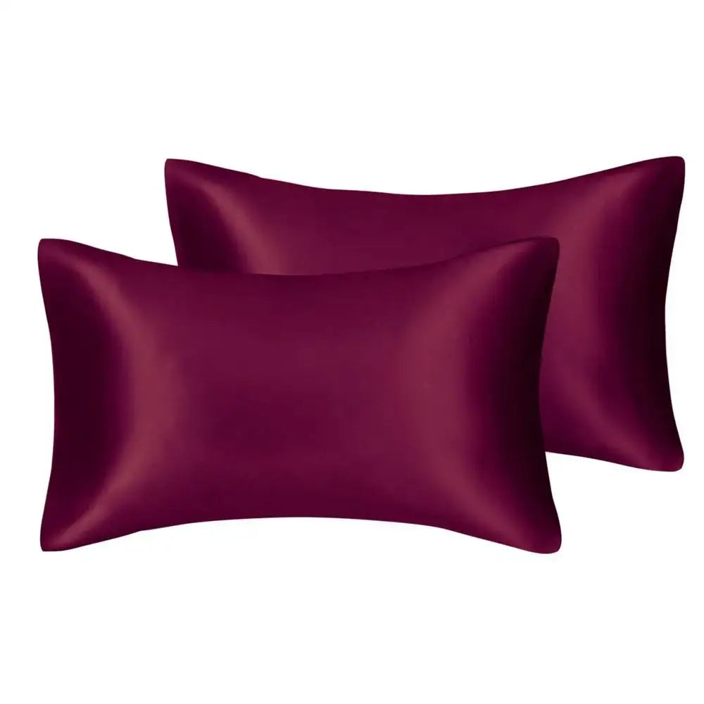 A pair of deep plum satin pillowcases with a smooth, lustrous finish.
