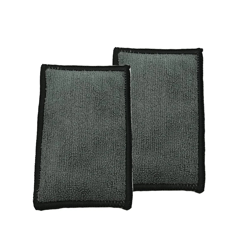 A pair of gray microfiber scrubbing sponges with black edges.