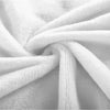 A close-up of a white flannel throw blanket folded and draped softly.